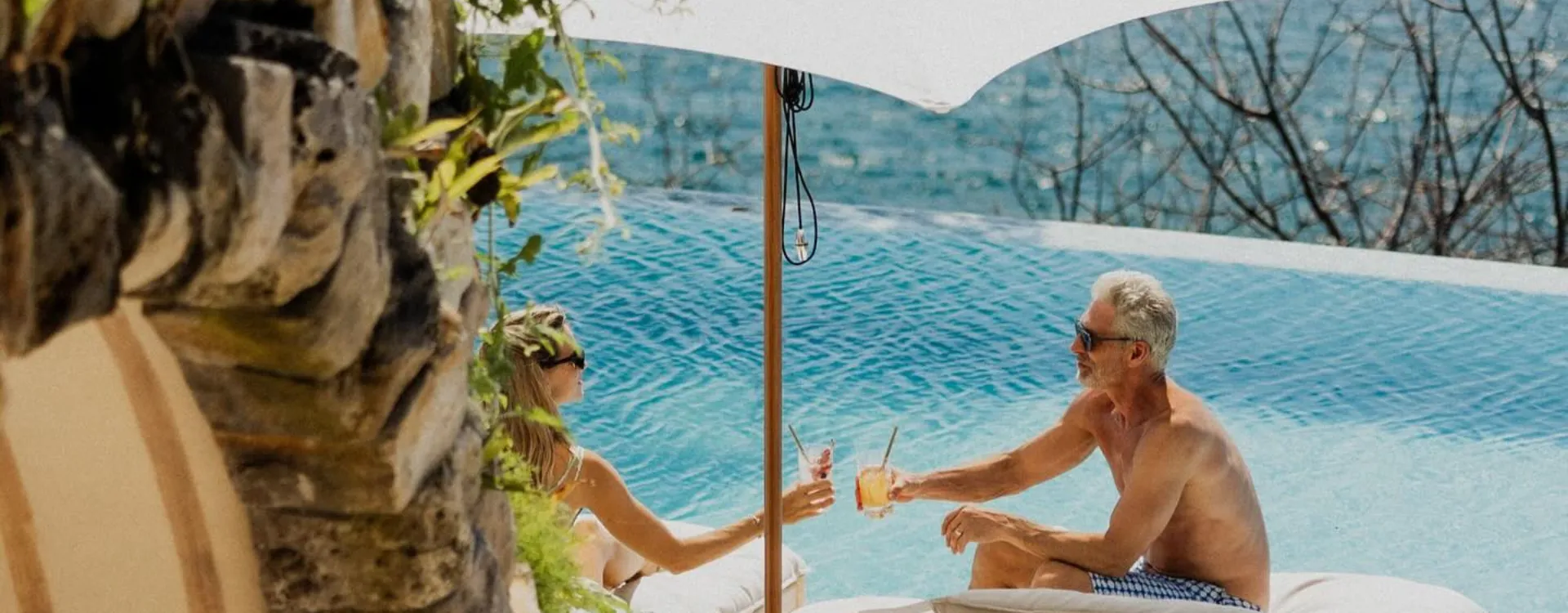 Two people cheersing at a pool