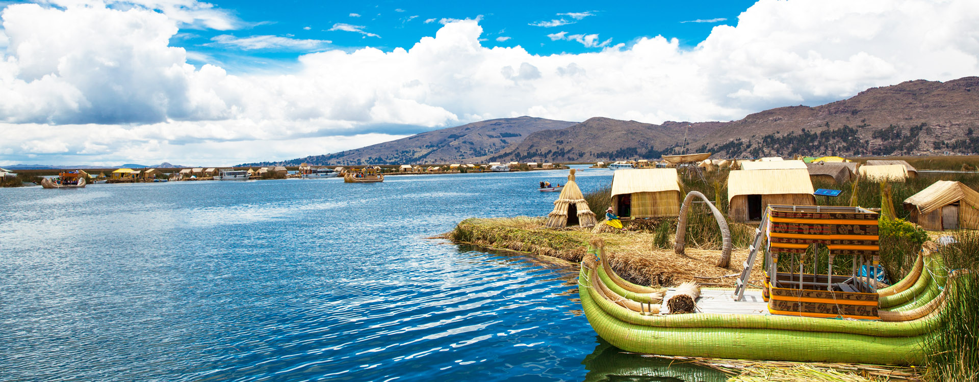 Unidentified women in traditional dresses welcome tourists in Uros Island