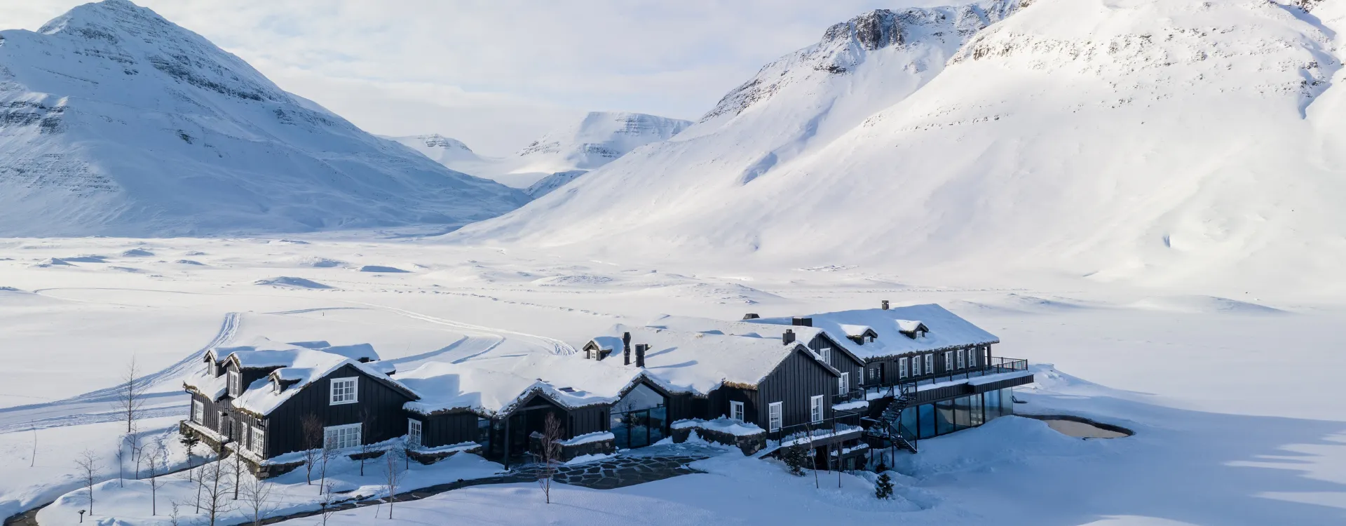 Deplar farm covered in snow amdist dramatic landscapes